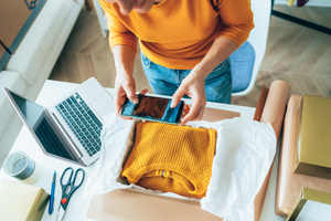 Ein Pullover wird zum Online-Weiterverkauf vorbereitet.