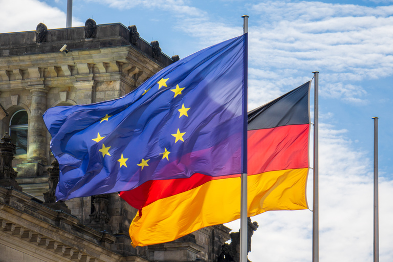 Die EU-Fahne und die Deutschlandfahne nebeneinander vor den Reichstagsgebäude